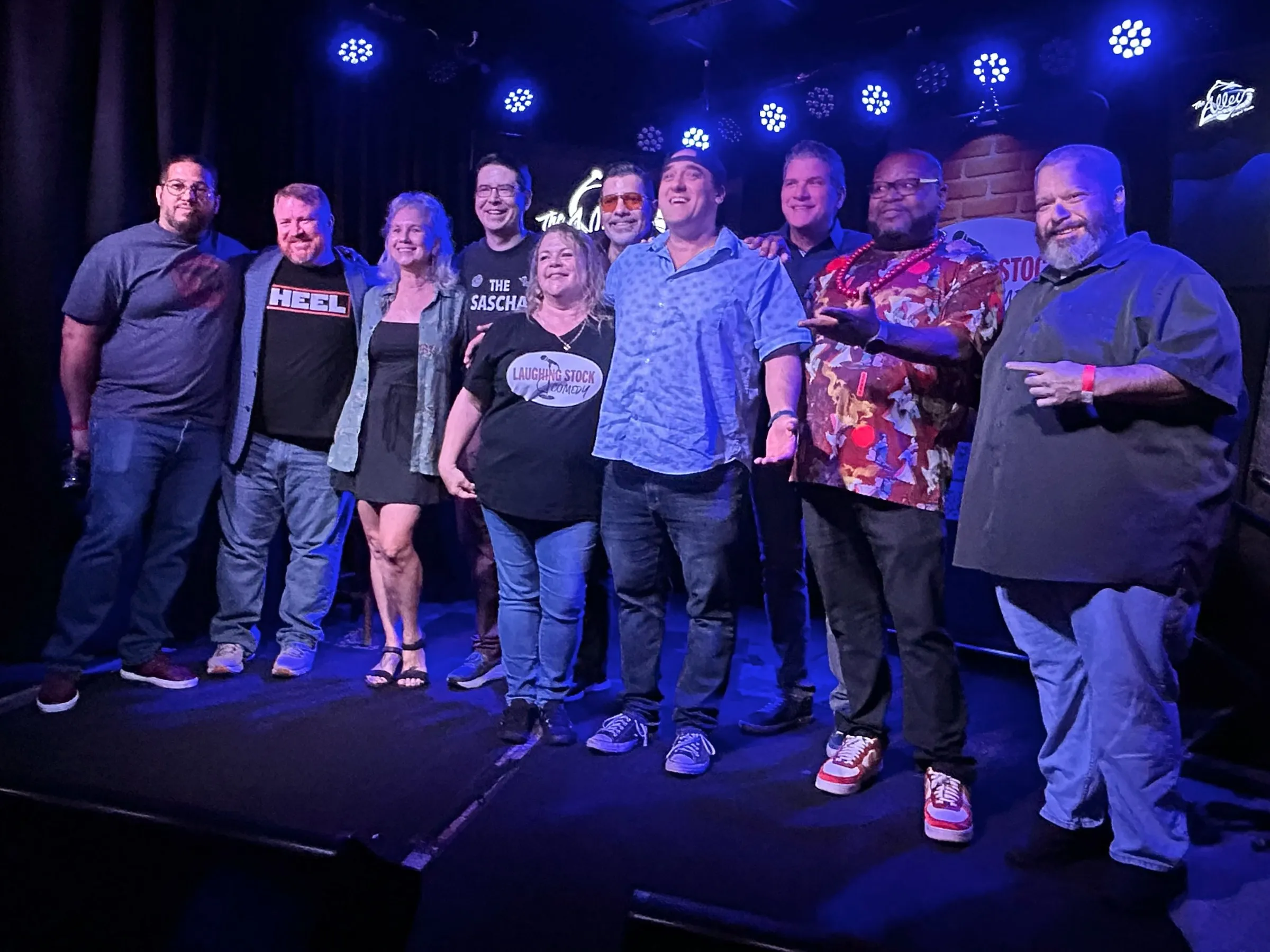 Laughing Stock Comedy comedians posing together on stage at The Alley