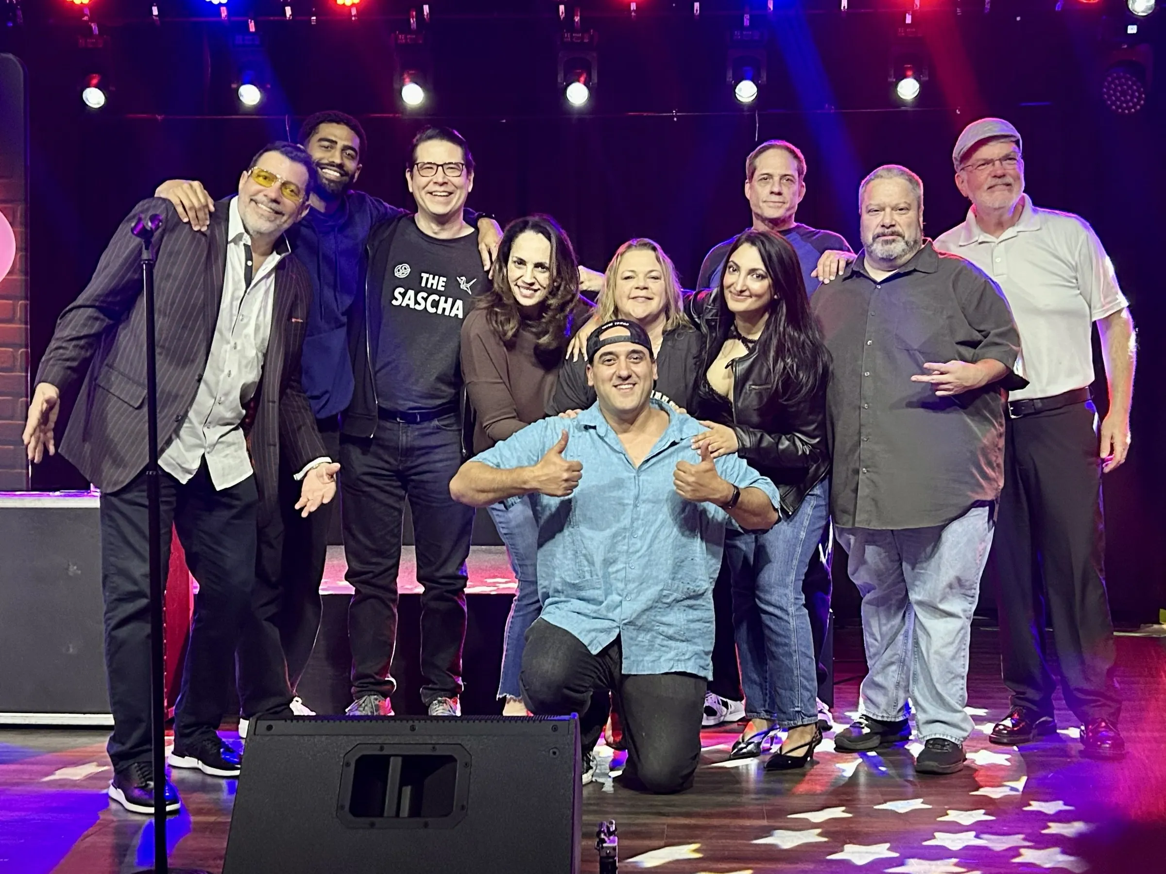 Laughing Stock Comedy comedians posing together on stage at Good Times Bar & Grill