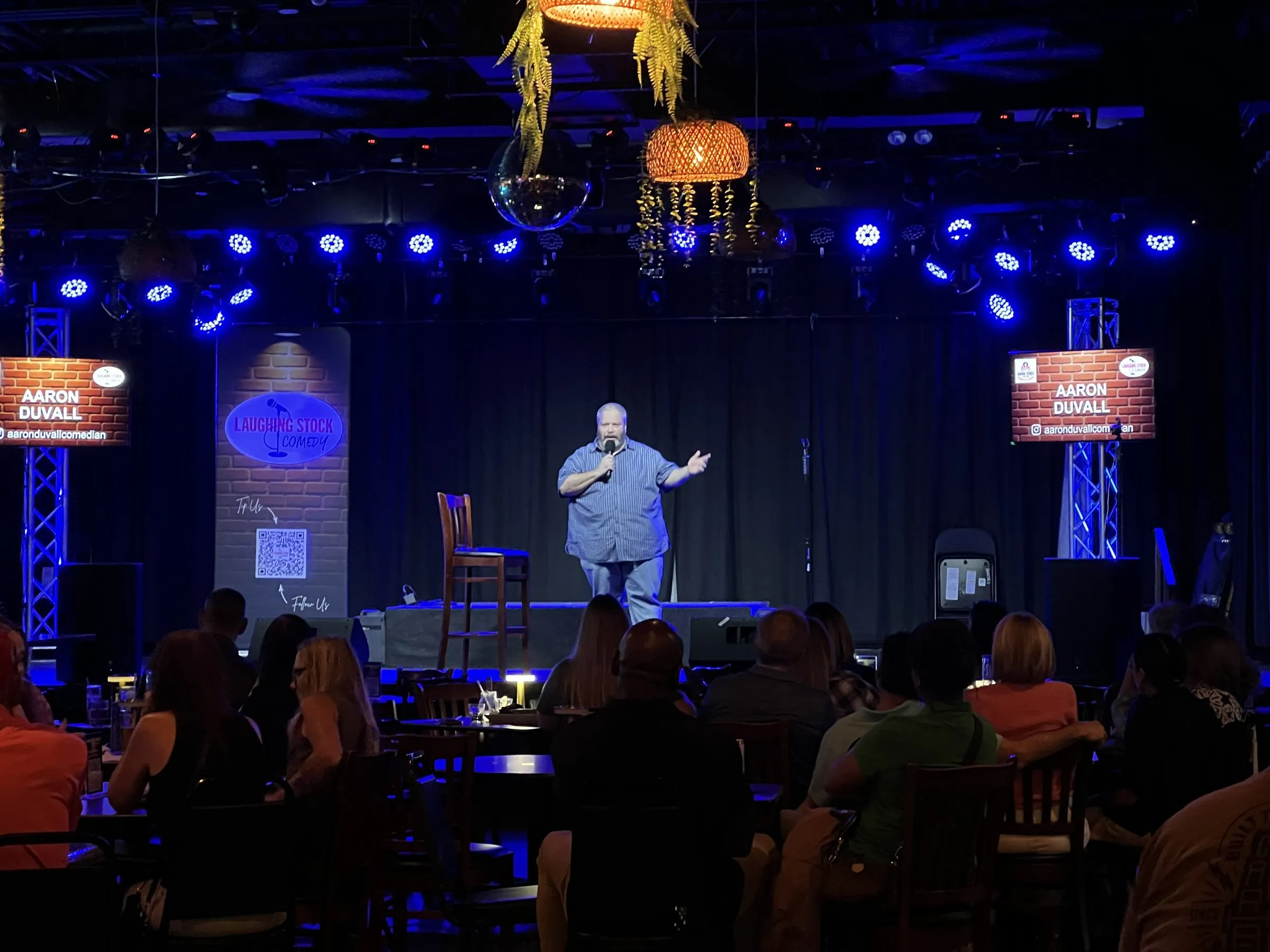 A comic on stage at Good Times Bar & Grill with the audience in front